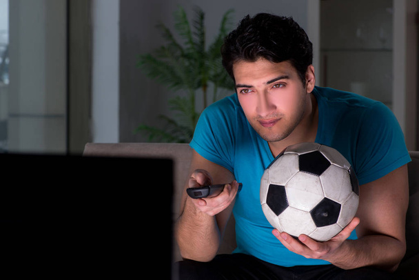 Νεαρός που βλέπει ποδόσφαιρο αργά το βράδυ - Φωτογραφία, εικόνα
