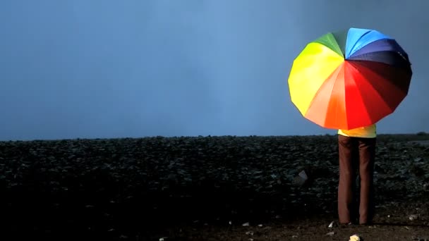 koncepcja strzał samotny kobieta przez wodospad z tęczy parasol - Materiał filmowy, wideo