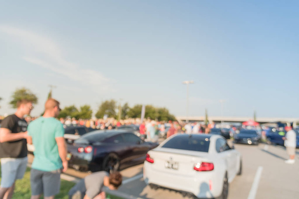 Wazig beweging diverse groep van mensen het bijwonen van de lokale auto show in Dallas, Texas, Usa. Drukbezette mensen surfen op auto's van alle jaren, merken en modellen. - Foto, afbeelding