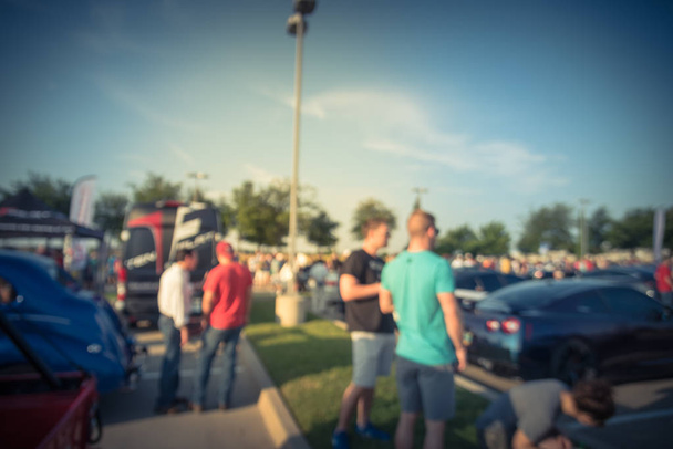 Vintage tone blurred motion diverse group of people attending local car show in Dallas, Texas, USA. Busy people browsing cars of all years, makes, and models. - Photo, Image