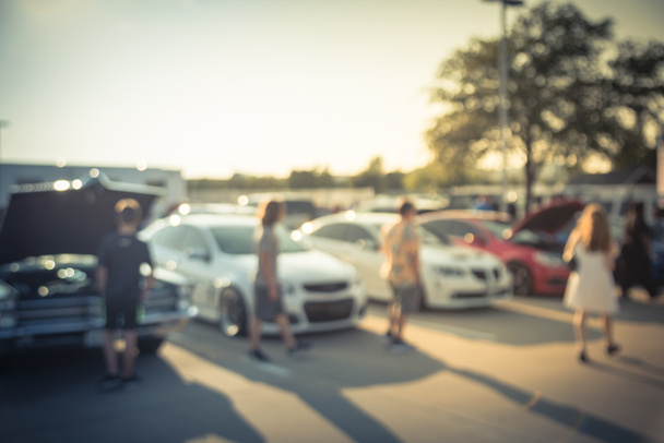 Un grupo diverso de personas que asisten a la exhibición local de autos en Dallas, Texas, Estados Unidos. Gente ocupada navegando autos de todos los años, marcas y modelos
. - Foto, imagen