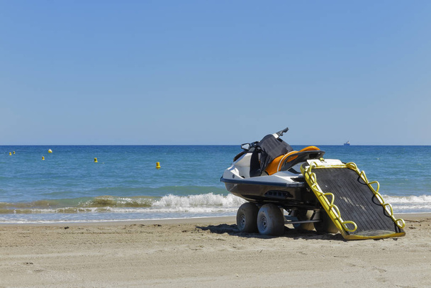 горизонтальный вид на пляж в солнечный день со спасательным гидроциклом на берегу
 - Фото, изображение