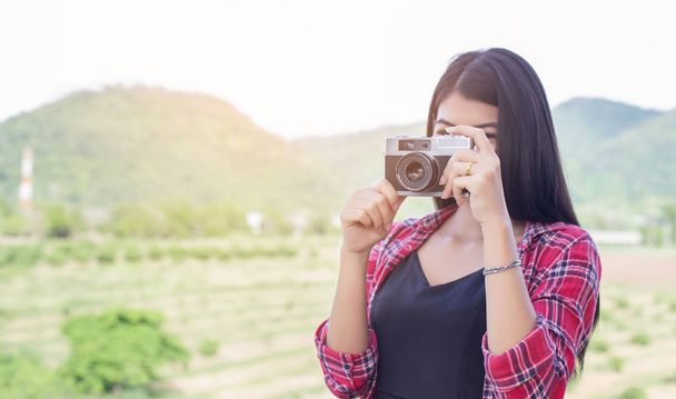 Молодая хипстерша-фотограф держит винтажную камеру
.  - Фото, изображение