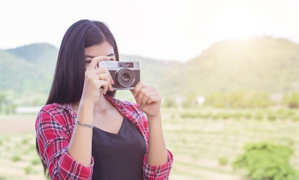 Joven fotógrafa hipster sosteniendo una cámara vintage
.  - Foto, Imagen