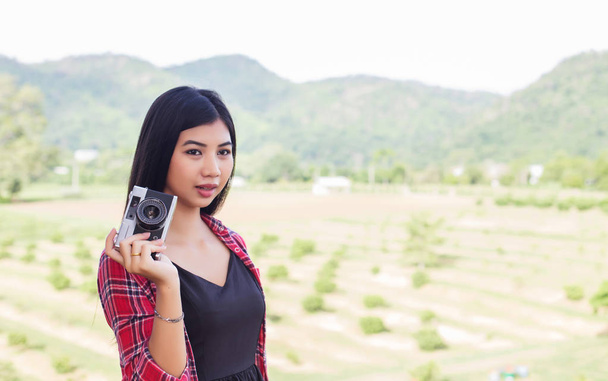 Hipster νεαρή γυναίκα φωτογράφος κρατώντας μια vintage φωτογραφική μηχανή.  - Φωτογραφία, εικόνα