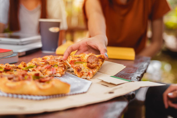 Gente celebrando con pizza en la mano. Concepto de comida y amistad. Tema Estilos de vida
 - Foto, Imagen