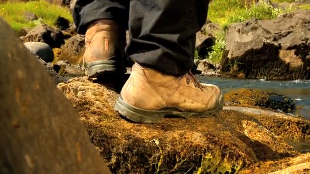 Pies de excursionista atlético caminando junto a un río glacial
 - Metraje, vídeo