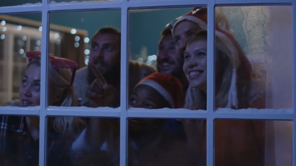 クリスマスの間に窓の外を見て興奮している友人 - 映像、動画