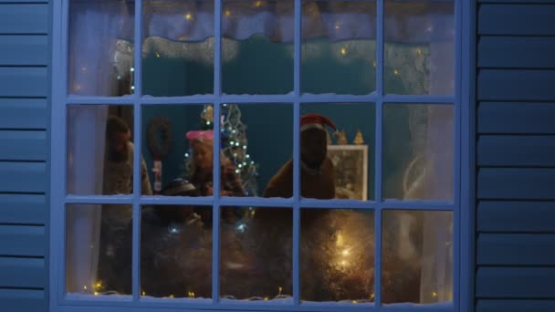 Amigos entusiasmados olhando pela janela durante o Natal
 - Filmagem, Vídeo