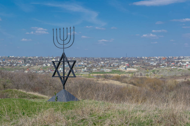 本枝の燭台は、ユダヤ教、イスラエルの国立宗教記号のシンボルです。六芒星のデビッド。ボグダノフカ村でホロコーストの犠牲者の記念碑。ウクライナ. - 写真・画像