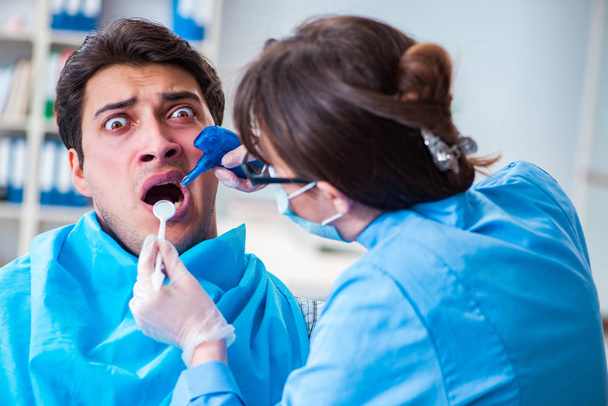 Patient afraid of dentist during doctor visit - Foto, Imagen