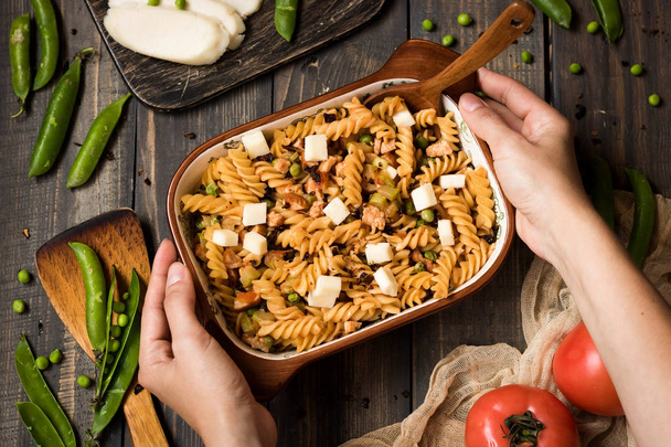 Fusilli pasta with zucchini, goat cheese and green peas on a dark rustic background - Photo, Image