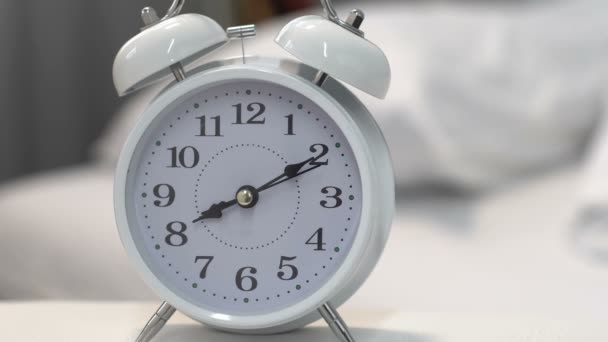 Hermoso reloj despertador blanco en la mesa cerca de la cama, gestión del tiempo y fecha límite
 - Metraje, vídeo