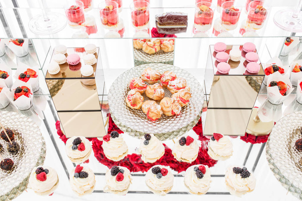 Candy bar with a lot of desserts, meringue, cupcake, fruit and sweet cakes. Sweet table for birthday or wedding. - Photo, Image