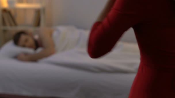 Mistress látszó-nél alszik az ember az ágyban fekve, és elhagyja a szobát, kapcsolat - Felvétel, videó