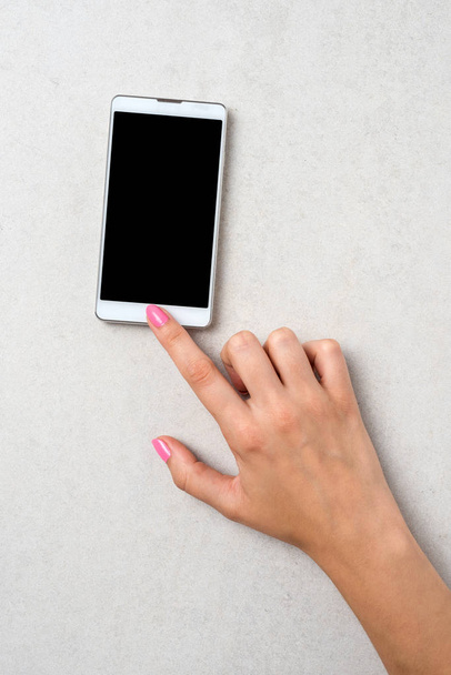 Woman using white smart phone. Close up - Φωτογραφία, εικόνα