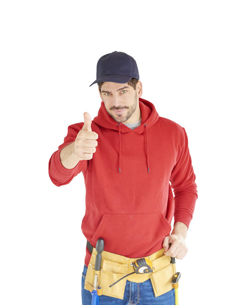Young handyman standing at isolated white bacgkround and giving thumbs up. - Foto, Imagen