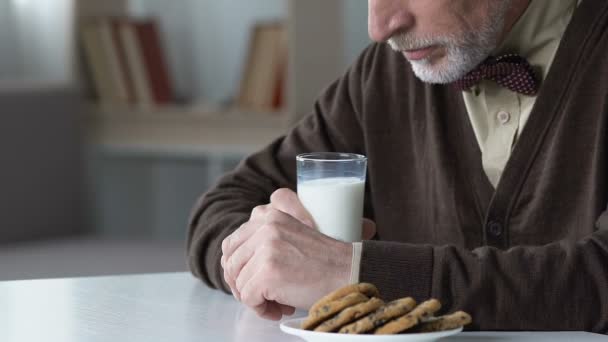 Szomorú öreg ember ül asztal hajlandó tejet, boldogtalan, idősek otthonában - Felvétel, videó