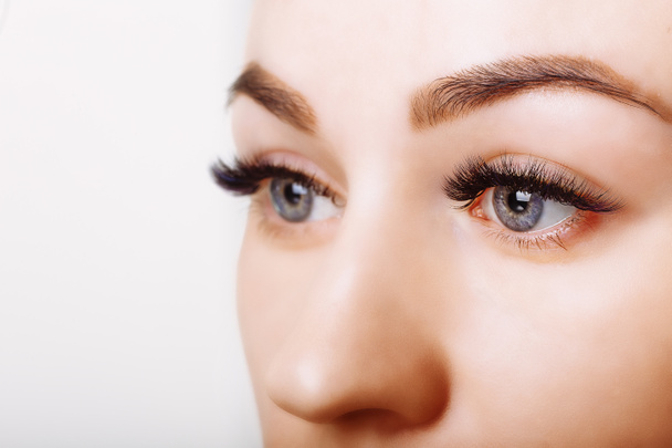 Eyelash Extension Procedure. Woman Eye with Long Eyelashes. Close up, selective focus. - 写真・画像