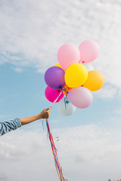 Девочка прыгает с воздушными шариками на пляже
 - Фото, изображение