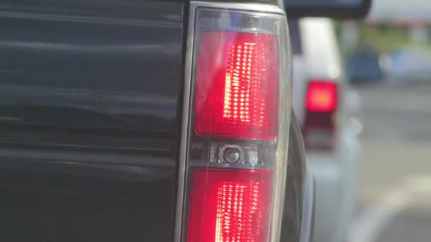 Close up van de achterlichten van een veicle bij een stop licht - Video