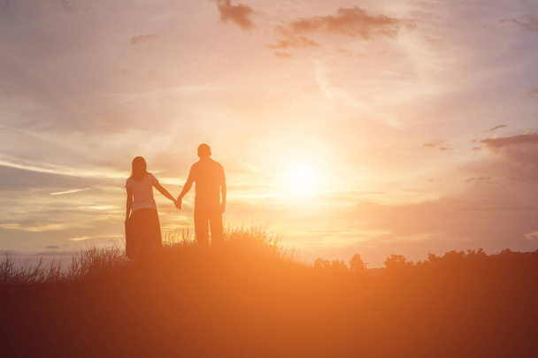 une silhouette d'un homme et d'une femme se tenant la main, marchant ensemble
. - Photo, image
