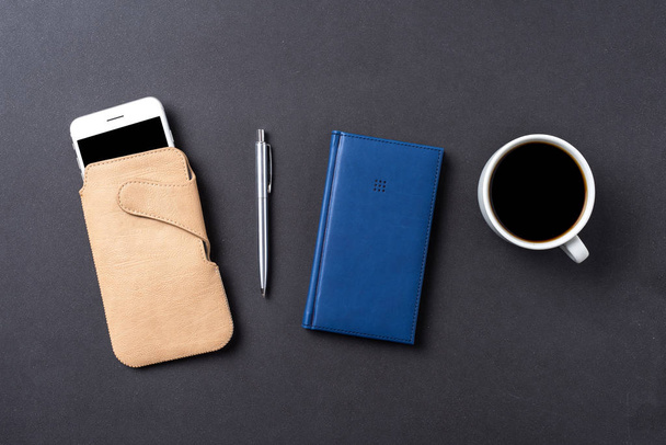 Office desktop with pen, smart phone and notebook - Foto, afbeelding