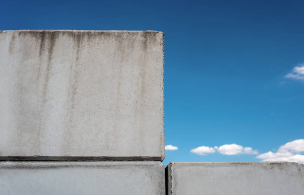 Gedetailleerde achtergrond van betonnen muur foto textuur op de mooie blauwe hemelachtergrond met witte wolken. - Foto, afbeelding
