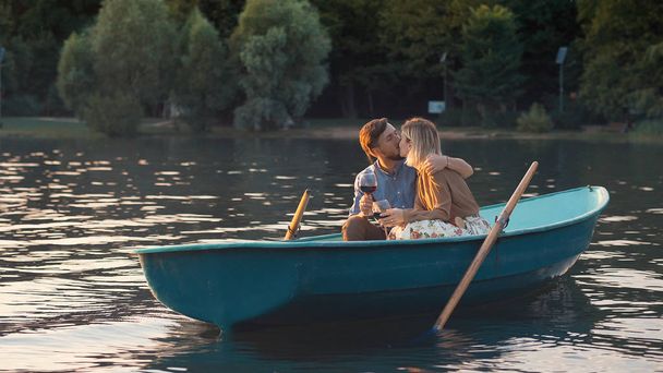 Kissing couple in a boat on a romantic date - Photo, image