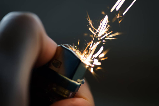 Lighters with flame sparking on dark background. Selective focus and shallow depth of field. - Foto, afbeelding
