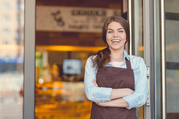 Mujer sonriente en un delantal en la panadería
 - Foto, Imagen