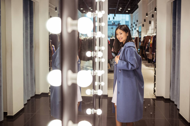 Young beautiful woman at the mirror in a store - Valokuva, kuva