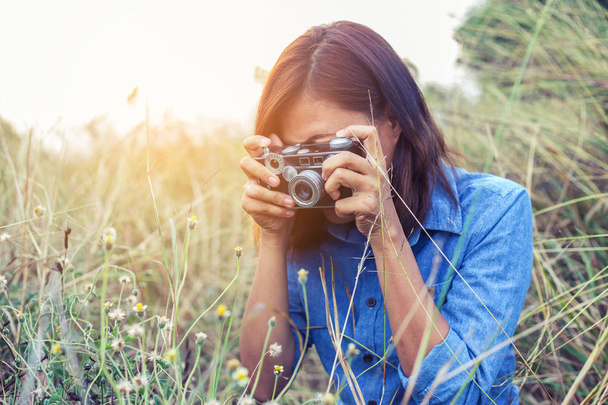 Ročník krásných žen fotografie postavení ruky hospodářství retro fotoaparát s východem slunce, měkký styl sen - Fotografie, Obrázek