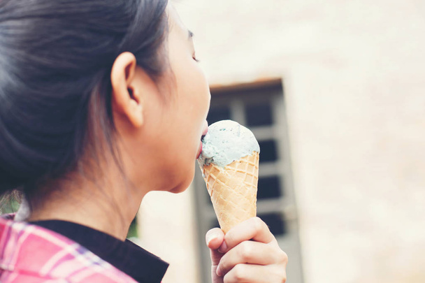 Крупним планом знімок морозива в руці жінки, що стоїть зі своїм другом. Літній відпочинок разом
. - Фото, зображення