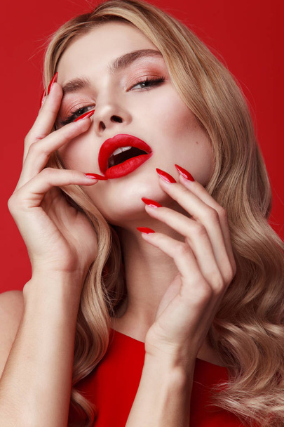 close-up beauty shot. curly blonde woman isolated on red background. red long nails. gorgeous model. luxury make-up for young lady. stylish wavy hairstyle. Beautiful sexy blonde woman. Fashion photo of a beautiful elegant blonde woman - Фото, зображення