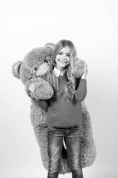 Girl hug big teddy bear on orange background - Foto, immagini