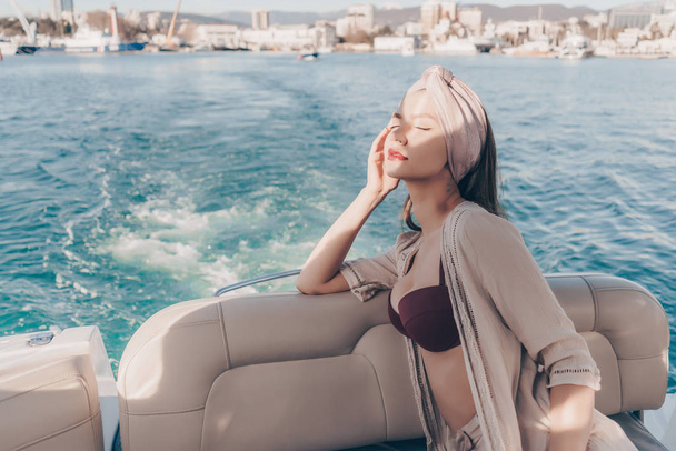 stylish beautiful girl sails on a ship on the Caribbean sea, enjoys the sun, closed her eyes - Φωτογραφία, εικόνα