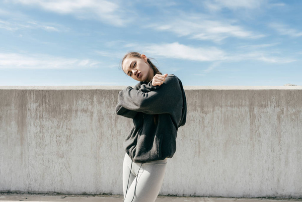 stylish young girl in black sweater poses outdoors, after workout - Fotoğraf, Görsel