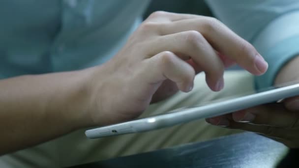 4k: Asyalı Genç adam kanepede oturan ve tablet PC'yi kullanma - Video, Çekim