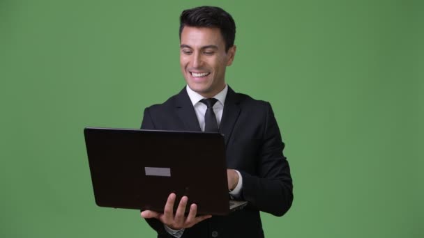 Fiatal jóképű spanyol üzletember zöld háttér - Felvétel, videó