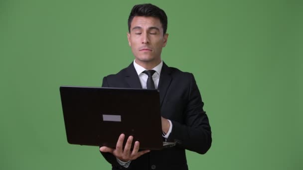Fiatal jóképű spanyol üzletember zöld háttér - Felvétel, videó