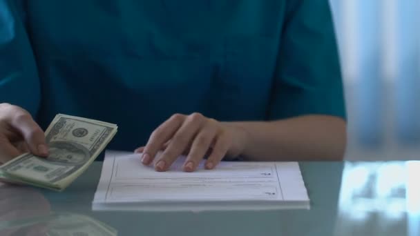 Nurse secretly giving money to doctor, corruption in medicine, money laundering - Materiał filmowy, wideo