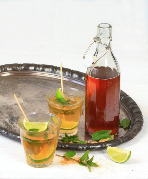 Σιρόπι μέντα με ασβέστη. Σιρόπι μέντας σε ένα μπουκάλι και λεμονάδα σε ποτήρια - Φωτογραφία, εικόνα