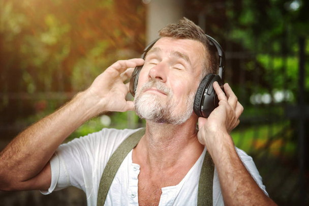 portrait of handsome bearded man in his 50s with headphones  - Foto, Imagen