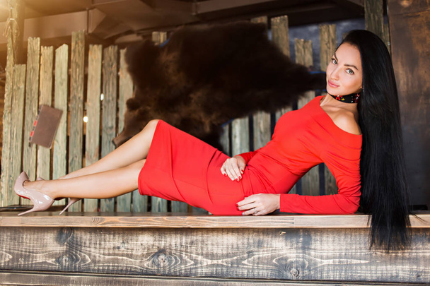 Portrait of a beautiful brunette woman lying on the bar. Youth, beauty concept - 写真・画像