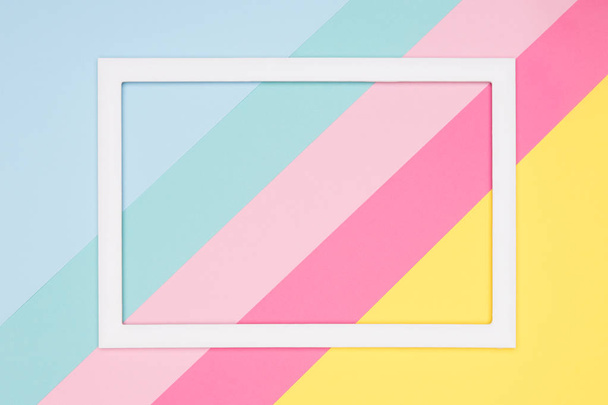 Abstract geometrical pastel blue, pink and yellow paper flat lay background. Minimalism, geometry and symmetry template with empty picture frame mock up. - Zdjęcie, obraz