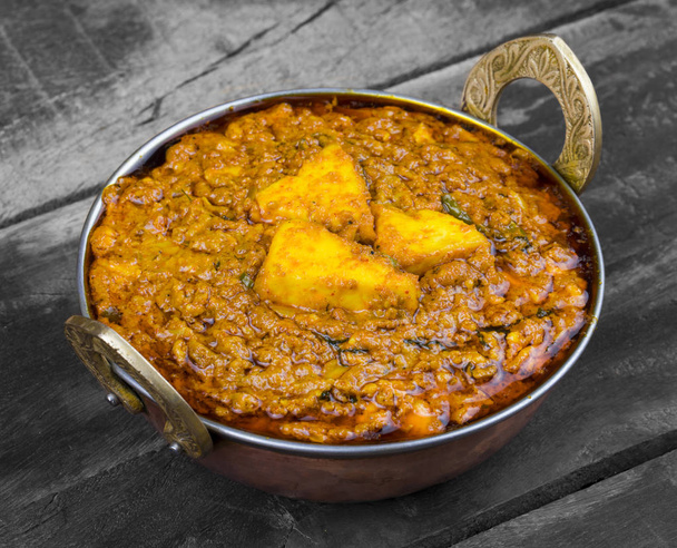 Cocina vegetariana india Kadai Paneer También conocido como Kadhai Paneer o Karahi Paneer es un plato indio de queso Paneer marinado servido en una salsa especiada sobre fondo de madera vintage
 - Foto, imagen