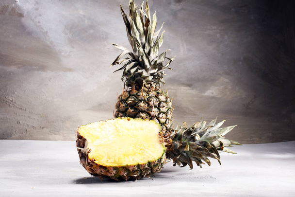 Ананас и половина ананасового руита. веганские вкусные закуски на белом каменном столе
. - Фото, изображение