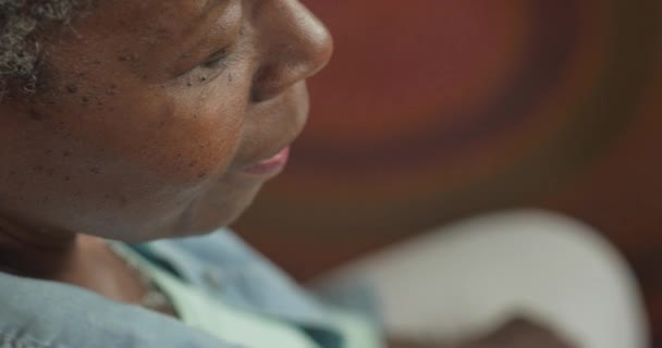 Besorgte ältere schwarze Frau hört etwas und blickt in die Kamera - Filmmaterial, Video