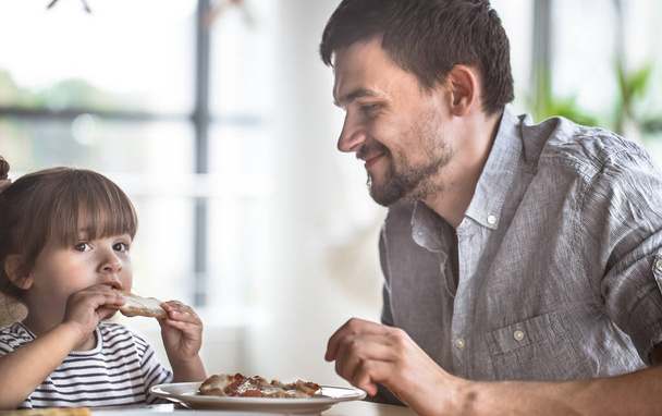 Dad and daughter eat pizza at a table in a cafe, celebrate his father's day, family values - Photo, Image